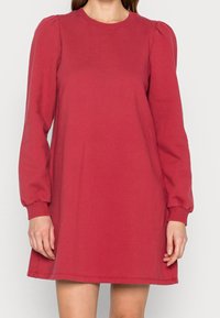 Rotes Sweatshirtkleid mit langen Puffärmeln, rundem Ausschnitt und lockerer Passform. Hergestellt aus weichem Material mit sichtbaren Nähdetails.