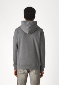 Gray hooded sweatshirt made from soft fabric, featuring ribbed cuffs and a straight hem. The back shows a textured finish and hood detail.
