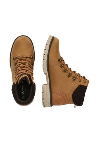 Bruna läderstövlar vid ankeln med fuskpälsfoder, rund tå, metallöglor och en beige gummisula med ett strukturerat mönster.