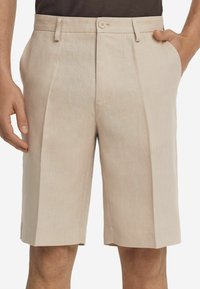 Beige Leinen-Shorts mit taillierter Passform, Vorderfalten, Seitentaschen und einem einfachen Knopfverschluss an der Taille. Glatte Textur.