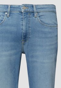 Hellblaue Jeans aus Denim mit mittlerer Leibhöhe, fünf Taschen und einem Reißverschluss. Mit kontrastierenden Nähten und einem leichten Verwaschungseffekt.