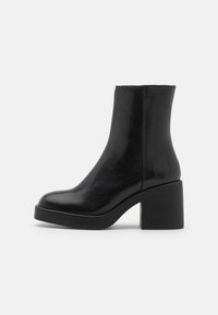 Black leather ankle boot with a rounded toe and chunky block heel. Smooth texture, minimal design, and no visible hardware or accents.