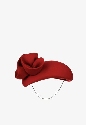 Red felt fascinator hat with a large sculpted flower detail and a thin black chin strap for securing.
