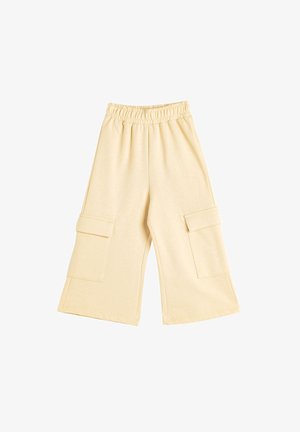 Lys beige cargo bukser lavet af blødt stof, med en elastisk talje og to store frontlommer på hver side. Bred ben-silhuet.
