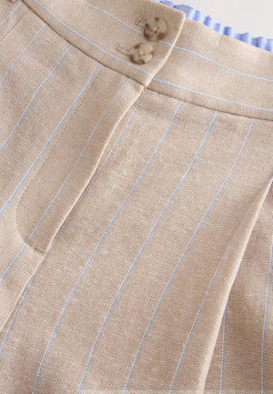 Beżowa tkanina lniana z jasnoniebieskimi pionowymi paskami, wyposażona w płaski pas i dwa brązowe guziki na górze.
