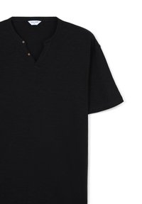 T-shirt nero a maniche corte con scollo henley, caratterizzato da due bottoni marroni e un tessuto morbido e texturizzato. Etichetta visibile all'interno del colletto.