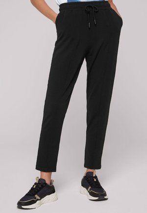 Pantalons de jogging noirs et fuselés avec une taille élastique et un cordon de serrage. Comprend des poches latérales et une texture de tissu lisse et léger.