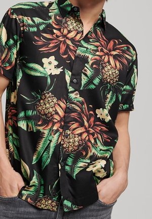 Schwarzes kurzärmliges Hemd mit floralem Muster, das grüne Blätter, orangefarbene und gelbe Blumen sowie Ananas zeigt. Mit Knopfleiste.