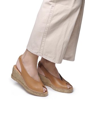 Brown leather wedge sandals with open toe, slingback design, woven jute heel, and contrasting smooth pink accents.