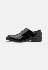 Zapato de vestir de charol negro con un acabado suave, puntera redondeada, cordones tradicionales y un tacón bajo.