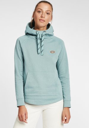 Haut à capuche bleu clair avec un motif texturé à pois, une poche frontale et des cordons rayés. Présente un petit logo sur la poitrine.