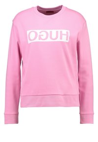 Sudadera rosa hecha de un tejido suave, con cuello redondo, mangas largas y un logo en bloque blanco con el texto "HUGO" en la parte delantera.