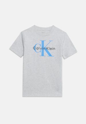 T-shirt gris clair à manches courtes avec les lettres bleues "cK" et le texte "Calvin Klein" centré sur la poitrine.