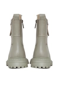 Világosszürke bokacsizma szintetikus anyagból, sima felülettel, masszív, barázdált talppal és két oldalt cipzárral a könnyű felvétel érdekében.