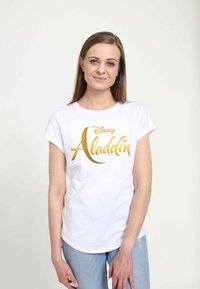 Bílý tričko z bavlny s zlatým nápisem "Disney Aladdin", krátké rukávy a kulatý výstřih, v kombinaci se světle modrými džíny.