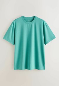 T-shirt en coton uni turquoise à manches courtes et col rond, posé à plat sur un fond blanc.