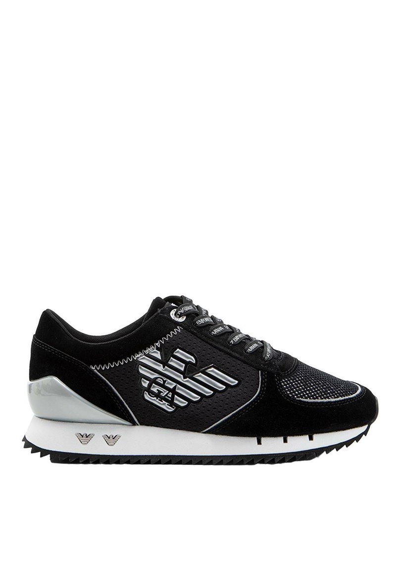 Sneaker sportivo nero con tomaia in rete, dettagli in suede, rifiniture argentate e suola in gomma testurizzata con motivo a zigzag.