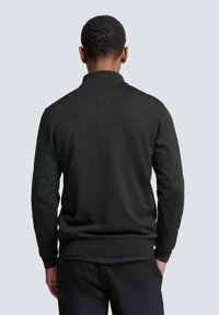 Donkergrijze, gebreide trui met een ronde hals, geribbelde manchetten en tailleband. Soepele textuur, getailleerd ontwerp en klassieke silhouet.