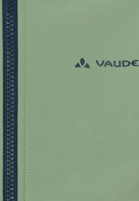 Lichtgroene, met ritssluiting, jas met een textuurafwerking, donkerblauwe rits en een in donkerblauw bedrukt Vaude-logo.