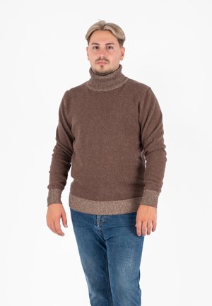 Brązowy sweter typu golf z prążkowanymi mankietami i dolnym brzegiem, wykonany z textured materiału. Połączony z niebieskimi dżinsami.