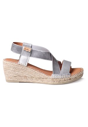 Sølv wedge sandal med krydsende stofstropper, en jute-indpakket mellemsål og en glat brun fodseng. Indeholder et lille logo-tag.