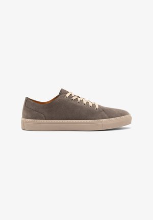 Gray suede sneaker with a low-profile design, beige rubber sole, and matching laces. Features minimal stitching and a rounded toe.