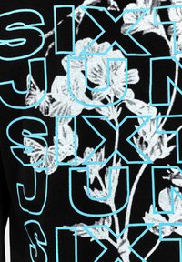 Tessuto nero con grandi e audaci lettere blu che formano la parola "SIX" e motivi floreali chiari, creando un contrasto grafico e un design testurizzato.