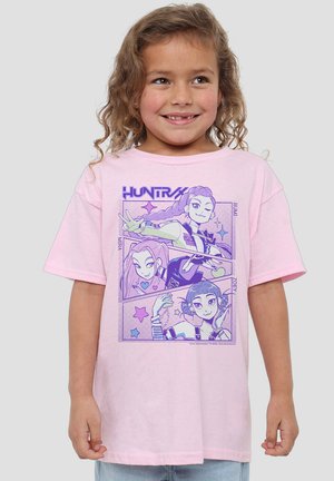 Rosa Baumwoll-T-Shirt mit grafischem Design, das vier illustrierte Charaktere in lila Tönen zeigt, umrahmt von Sternen und Akzenten. Kurze Ärmel.