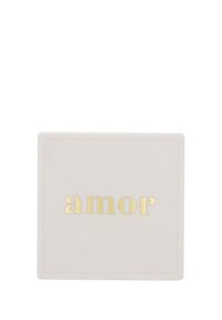 Vit rektangulär låda med ordet "amor" i guld små bokstäver centrerat på locket.