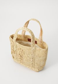 Vevd stråveske i naturlig beige med teksturerte blomstermotiver, to runde håndtak og en uforet innside.