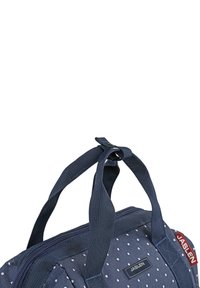 Bolso de tela azul marino con lunares blancos, cuenta con asas dobles y una apertura con cremallera. Placa con el logo "JASLEN" en la parte frontal.