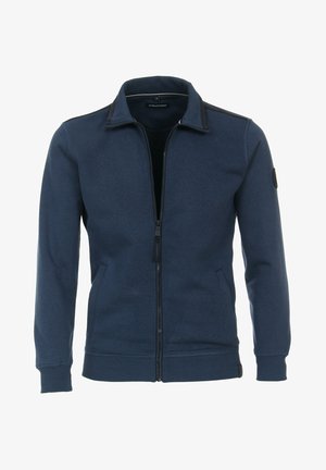 Veste bleu marine à fermeture éclair avec poignets et ourlet côtelés, col montant, poches latérales et écusson noir sur la manche gauche.
