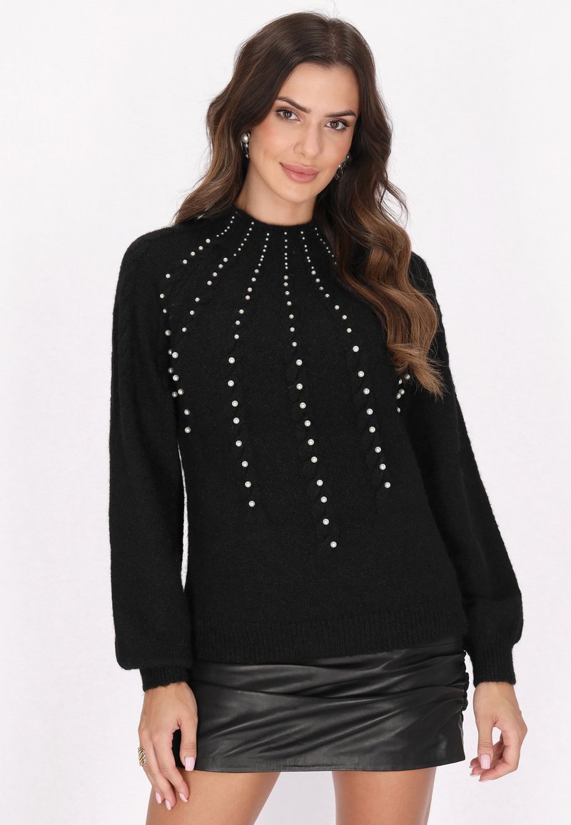 Jersey negro hecho de material suave, con acentos de perlas dispuestos en un patrón vertical. Las mangas abullonadas y el dobladillo acanalado completan el diseño.