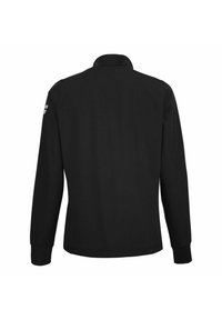 Chaqueta negra de manga larga con cuello alto, costuras visibles y rayas reflectantes en la parte superior de la manga izquierda, vista desde atrás.