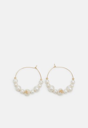 Gold hoop earrings adorned with varying sizes of white pearls, including one pearl on each earring featuring a gold leaf design.