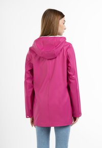 Jachetă waterproof roz cu glugă, având o textură netedă și elegantă, cu închideri cu snur la încheieturi. Proiectată pentru utilizare în aer liber.