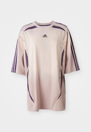 Svetloružové oversize tričko s fialovými akcentmi a dizajnovými líniami. Má krátke rukávy a logo Adidas na hornej časti hrudníka.