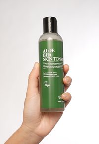 Zielona plastikowa butelka toniku do skóry Aloe BHA, cylindryczny kształt, czarna nakrętka, 200 ml, etykieta z białym tekstem, logo wegańskie i przezroczysty płyn wewnątrz.