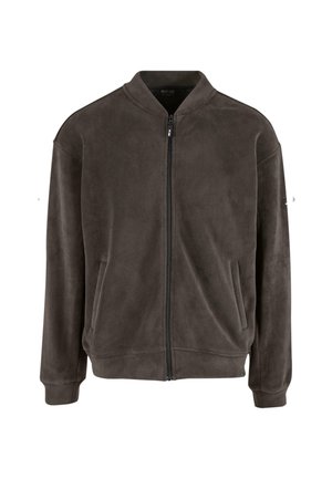 Brązowa bomberka z polaru z zapięciem na zamek, bocznymi kieszeniami i ściągaczami przy mankietach. Gładka tekstura i luźny fason; brak widocznych wzorów lub logotypów.