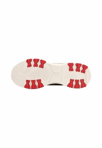 Sole della scarpa con base bianca, dotata di grip in gomma rossa e motivo testurizzato; progettata per aderenza e stabilità.