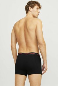 Schwarze Baumwoll-Boxershorts mit einem roten "JACK & JONES"-Logo am Bund. Das Design zeichnet sich durch eine enge Passform und eine saubere, nahtlose Verarbeitung aus.