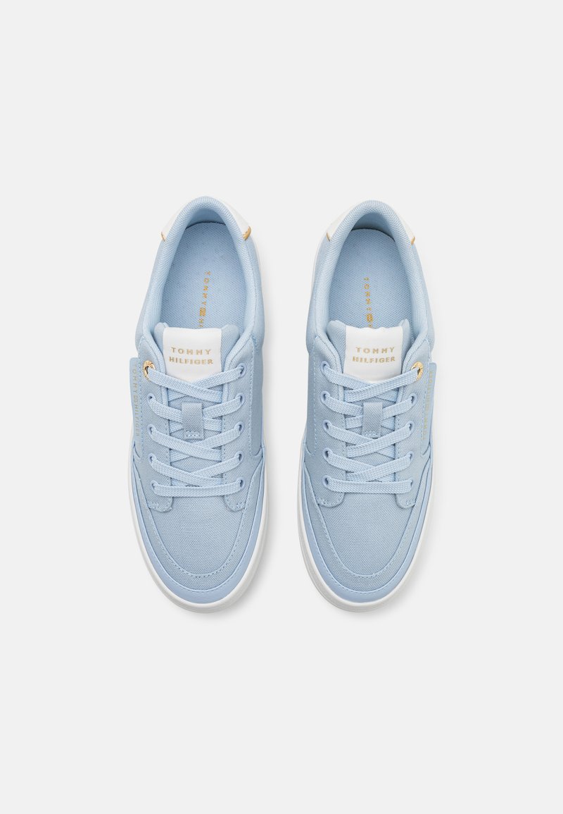 Jasnoniebieskie płócienne trampki z białymi gumowymi podeszwami, zaokrąglonym noskiem i kontrastującymi sznurowadłami w odcieniu. Posiadają złote akcenty oraz detal z logo na języku.