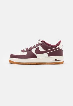 Nike Air Force 1 lavt snøresko i bordeaux og hvidt læder med gummisål og hvide snørebånd, vist fra siden på en hvid baggrund.