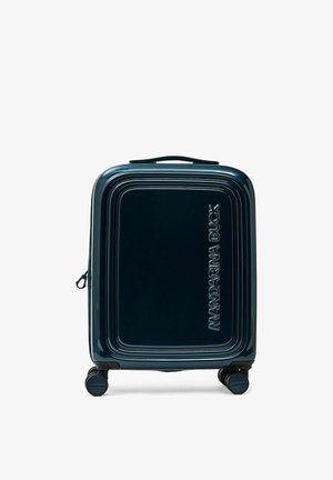 Valise rigide bleu foncé avec quatre roues pivotantes et "MANDARINA DUCK" embossé verticalement sur le panneau avant.