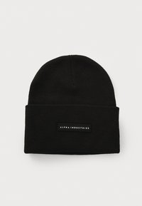 Black knit beanie with a folded cuff, featuring a rectangular black label with white text reading "ALPHA INDUSTRIES." Simple and unembellished design.