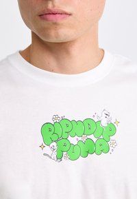 Hvit skjorte med grønne boblebokstaver "RIPNDIP PUMA," to lekne hvite katter, små blomster og funker på brystet.
