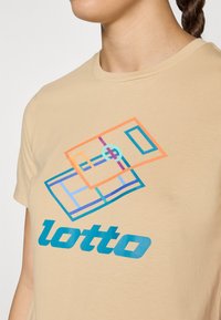 Beige kokvilnas T-krekls ar ģeometrisku daudzkrāsainu grafiku, kurā attēlots vārds "lotto" zilā krāsā uz vienkrāsaina fona.