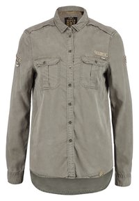 Koszula z długim rękawem w jasnoszarym kolorze, wykonana z bawełny, posiadająca dwie kieszenie na wysokości klatki piersiowej, zapięcie na guziki oraz delikatnie teksturowaną tkaninę z akcentami logo.