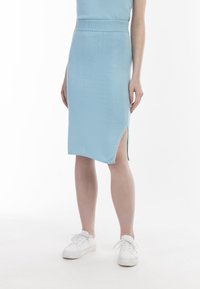Fustă tricotată ribbed, de culoare albastru deschis, cu o siluetă ajustată, fanta laterală și o textură netedă. Asortată cu adidași albi.