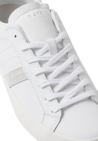 Sneaker bianca in pelle con dettagli in suede, lacci piatti e una striscia laterale texturizzata. Logo "D.A.T.E." impresso sulla linguetta.